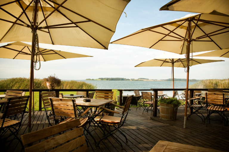 Imagen de una terraza en Barcelona, cumpliendo con la normativa y mostrando el diseño adecuado con mesas, sillas y parasoles.